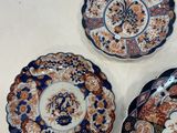 three plates with different designs on them sitting on a white surface