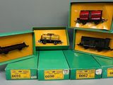 quatre cartons contenant des trains miniatures posés sur une table dans une pièce