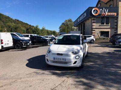 une petite voiture blanche garée devant un bâtiment