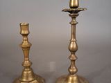 pair of antique brass candlesticks on a grey background