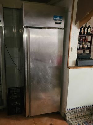 a stainless steel refrigerator in the corner of a kitchen