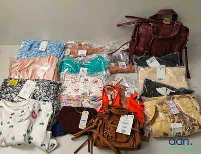 many bags of clothing and a purse on the table