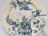a blue and white plate with birds and flowers on it