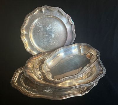 deux plateaux en argent posés l'un sur l'autre sur une table