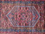 a pink and blue rug with a medallion design on it