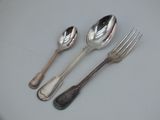 three spoons and a fork sitting on a table