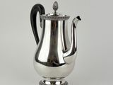 an antique silver tea pot with a black handle on a white background