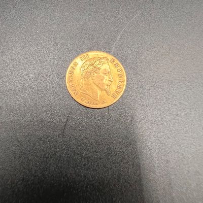 gros plan d'une pièce d'or sur une surface noire