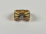 gros plan d'une bague en or avec un diamant au centre