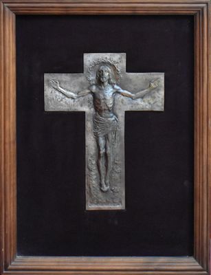 un gros plan d'une croix en métal sur fond noir