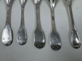 six spoons are lined up in a row on a table