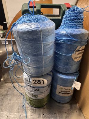 several rolls of blue yarn are in a box on the floor