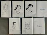 six books with drawings of people on them sitting on a table