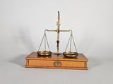une image représentant une balance posée sur une caisse en bois