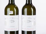 deux bouteilles de vin posées l'une à côté de l'autre sur une surface blanche