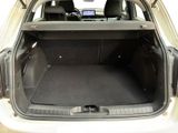 the back of a white car with the trunk open and the seats down