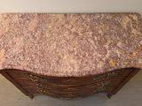 a marble top chest of drawers in the corner of a room