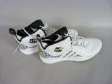 white and black sneakers with gold accents on them on a white surface