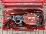 a red tool box with a drill in it on the floor