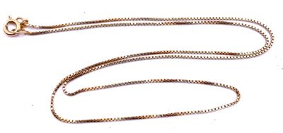 a gold chain that is laying on a white surface