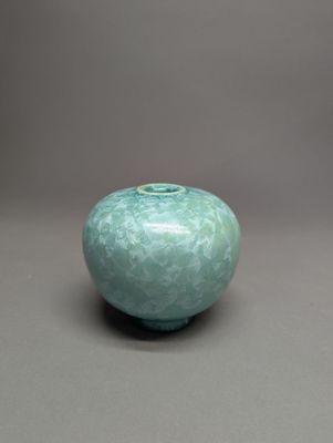 un vase vert posé sur une table