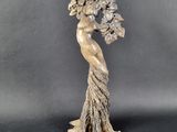 une statue représentant une femme tenant un bouquet de fleurs à la main