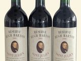 trois bouteilles de vin rouge posées sur une table blanche