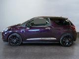 the small purple car is parked in a room with a white wall