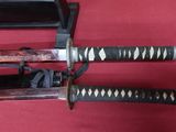 two swords that are on display on a red surface