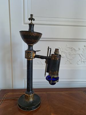 une lampe noire et dorée posée sur une table en bois