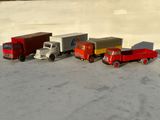 plusieurs camions jouets sont alignés sur une surface blanche
