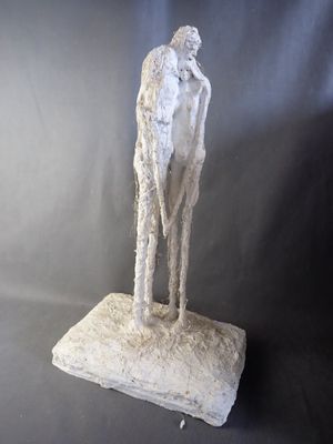sculpture of a man standing on a rock with a goat on it ' s back