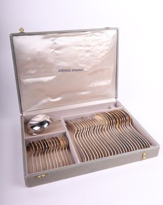 un service d'argenterie présenté dans un coffret en argent sur fond blanc