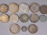 plusieurs types de pièces de monnaie sont disposés sur une surface blanche