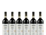 quatre bouteilles de vin sont alignées sur une surface blanche