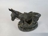 bronze statue of a donkey with a saddle on its back