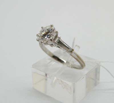 un gros plan d'une bague en diamant posée sur une boîte transparente