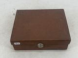 a brown leather box with a lock on top of a white surface