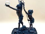 a statue of a man and a boy holding a light bulb