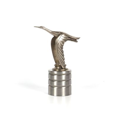 une statue en argent représentant un oiseau posé sur une pile de pièces d'argent