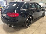 the rear end of a black car parked in a garage