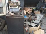 un tas de vieilleries dans un garage, avec un camion en arrière-plan