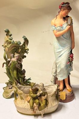 une figurine représentant une femme debout à côté d'un pot de fleurs