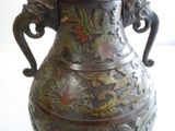 un grand vase en métal avec une poignée sur une table