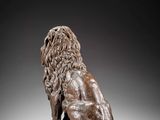 a bronze statue of a lion sitting on a pedestal