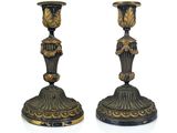 pair of black and gold candlesticks sitting on a white surface