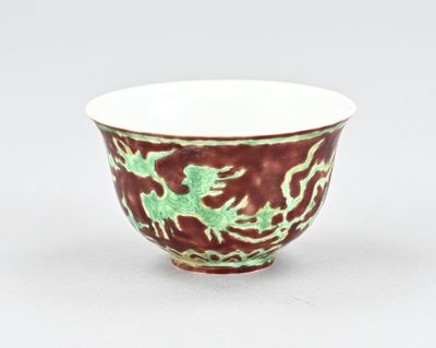 un bol rouge et vert orné d'un motif représentant un dragon