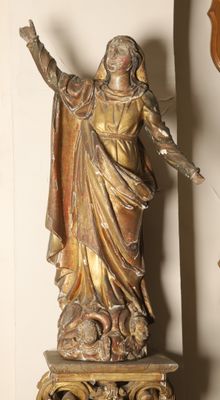 a statue of a woman holding a cross on a table