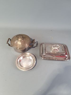 un plat en argent avec un couvercle en argent, à côté d'un plat en argent avec un couvercle en argent
