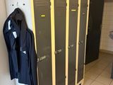 deux casiers dans une salle de bains équipée d'un lavabo et d'un miroir